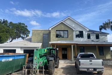 Exterior of remodeled home with dumpster and pick-up truck